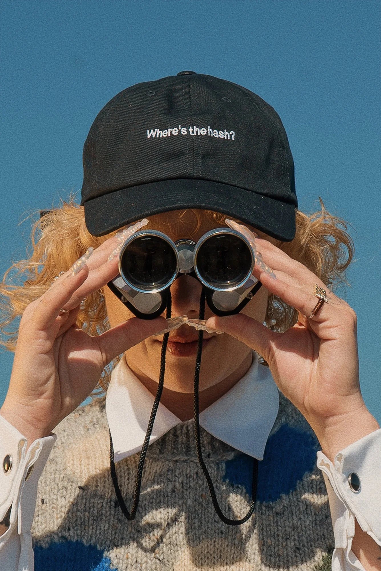 Puffco "Where's the hash?" black washed cotton strapback cap with white embroidery, worn by a person looking through binoculars.